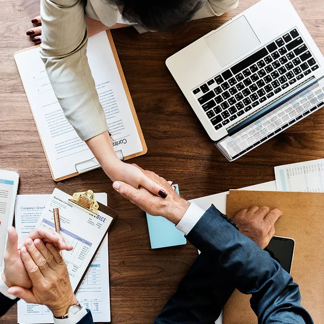 A man and woman shaking hands at the start of a new web design project